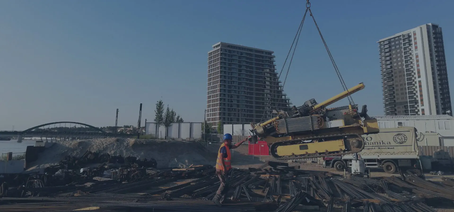 Istražni radovi na gradilištu u gradu, kran i stambene kule u pozadini